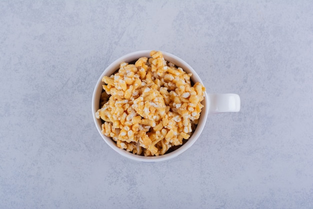 Foto gratuita taza de cerámica de caramelos duros con nueces sobre piedra.