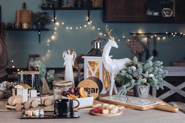 Taza de cerámica negra sobre mesa de madera con comida en el fondo. Concepto de víspera de año nuevo