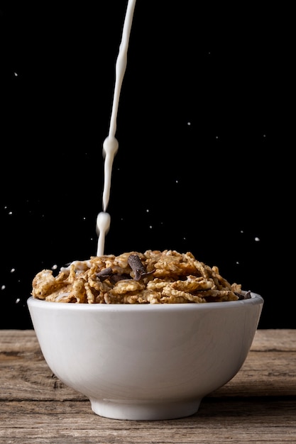 Foto gratuita taza de cereal con chorrito de leche