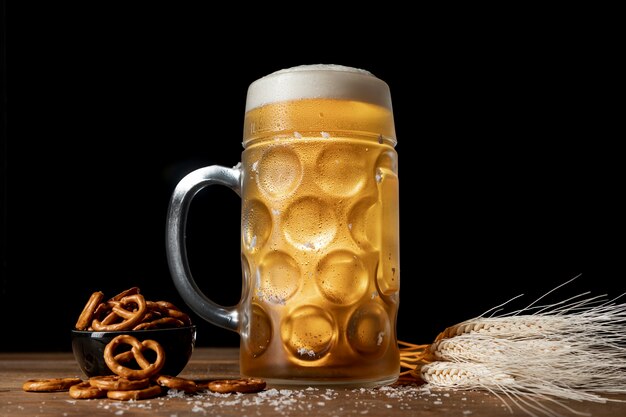 Taza con cerveza rubia y pretzels