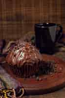 Foto gratuita taza de chocolate caliente y muffin en tablero de madera