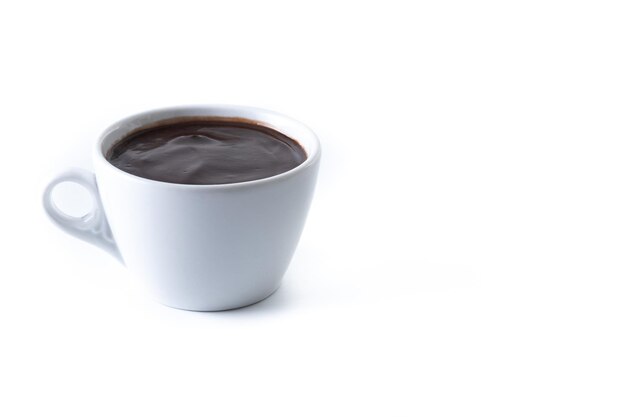 una taza de chocolate está sobre una superficie blanca.