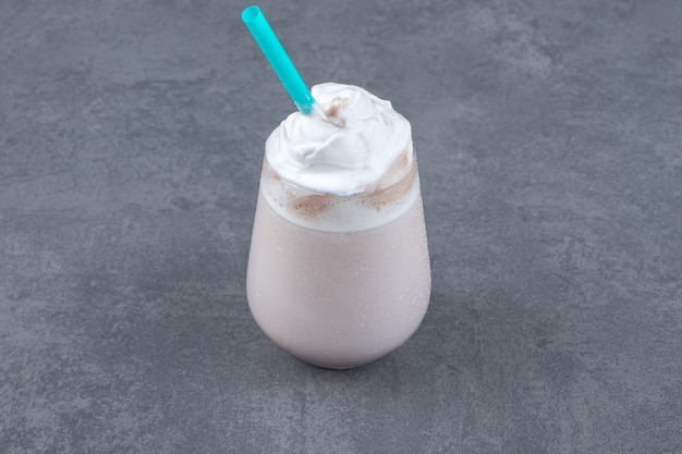 Una taza de cristal de batido dulce con crema batida. Foto de alta calidad