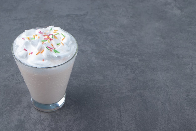 Una taza de cristal de batido dulce con crema batida. Foto de alta calidad