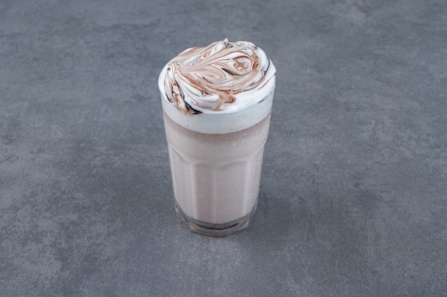 Una taza de cristal de batido dulce con crema batida.