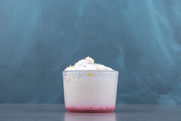 Una taza de cristal de batido dulce con crema batida.