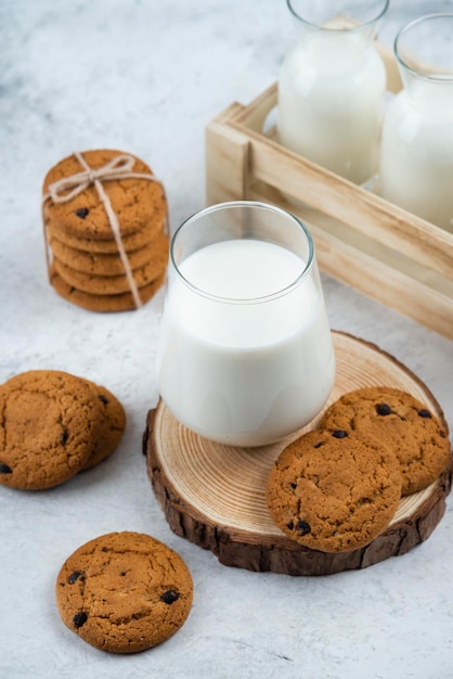 Una taza de cristal con galletas de chocolate en un escritorio de madera.