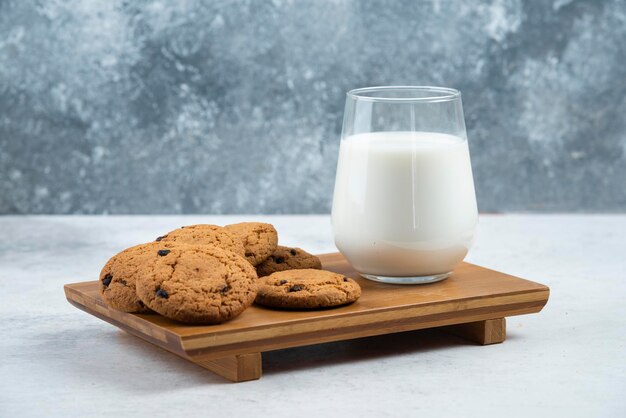 Una taza de cristal con galletas de chocolate en un escritorio de madera.