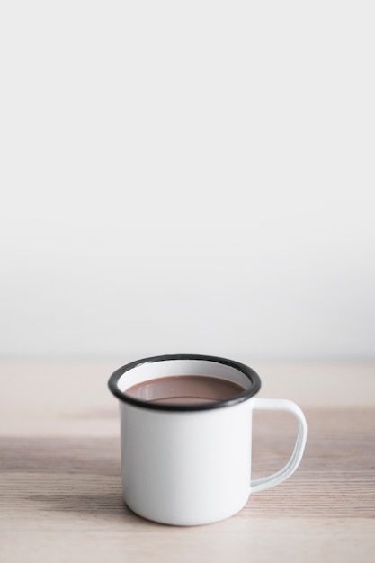 Taza de deliciosa bebida de cacao en la mesa de madera