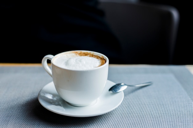 Taza de delicioso café en el escritorio en la cafetería