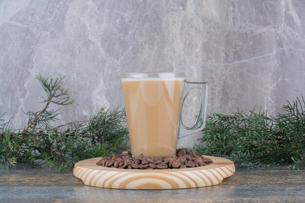 Una taza de delicioso café con granos de café sobre tabla de madera. Foto de alta calidad