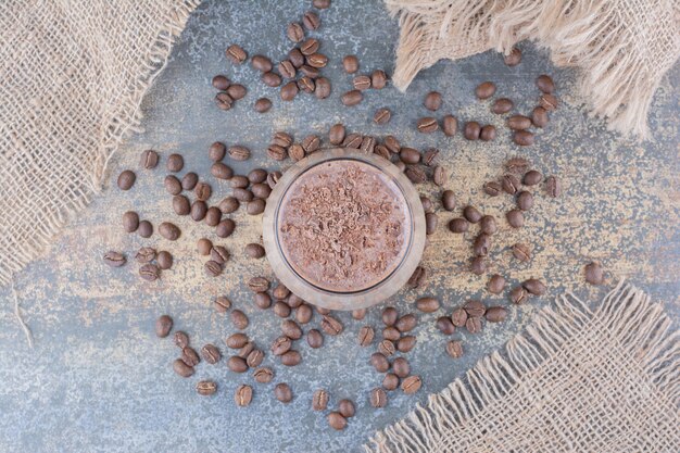 Una taza de delicioso café con granos de café sobre tabla de madera. Foto de alta calidad