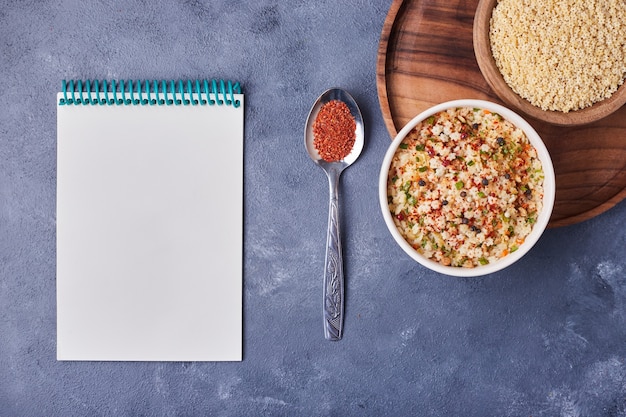 Una taza de ensalada de frijoles con un libro de recetas a un lado.