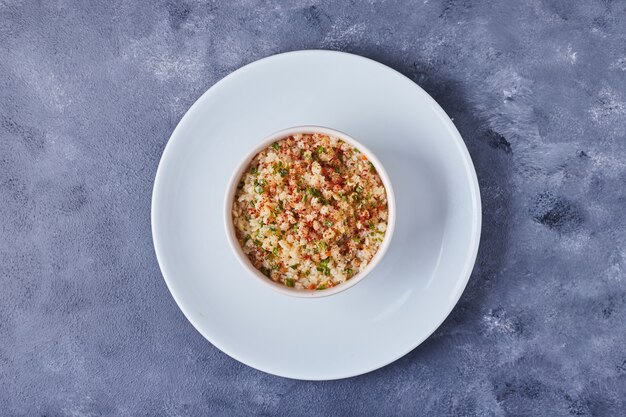 Foto gratuita una taza de ensalada de frijoles en un plato blanco.