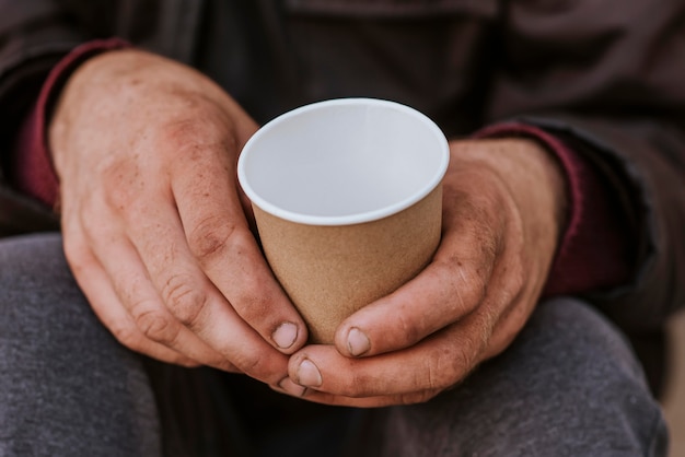 Foto gratuita taza de explotación de hombre sin hogar