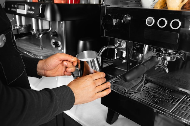 Taza de explotación de mano de primer plano con leche