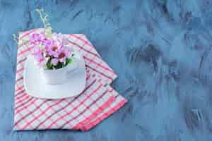 Foto gratuita taza de flores púrpuras naturales con hojas en azul.