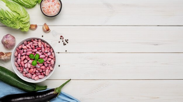 Taza con frijoles rojos activados decorada con hojas de albahaca, lista para cocinar