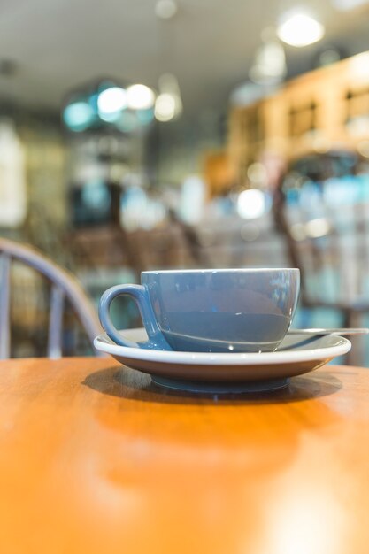 Taza gris en la mesa de madera en café