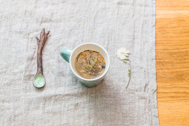 Taza con infusión de hierbas en la mesa