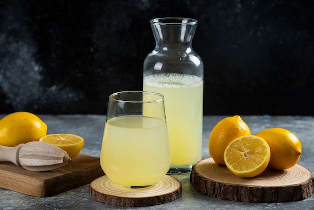 Una taza de jugo de limón sobre tabla de madera.