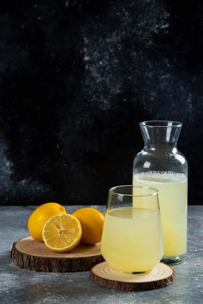Una taza de jugo de limón sobre tabla de madera.