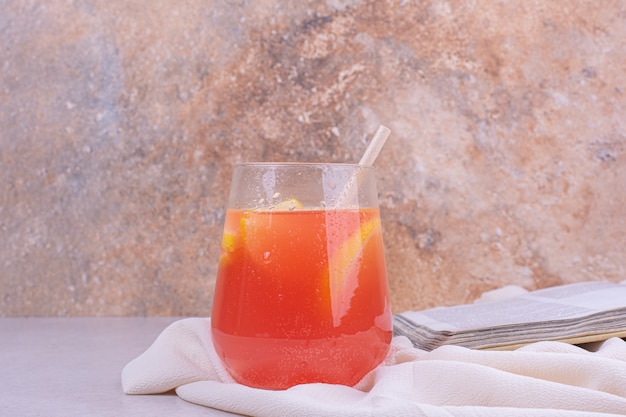 Una taza de jugo con rodajas de fruta.