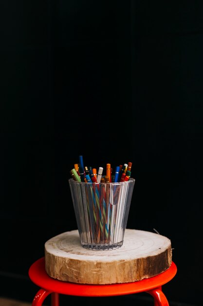 Taza de lápices en taburete