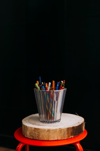 Taza de lápices en taburete