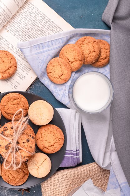 Taza de leche con galletas y libro