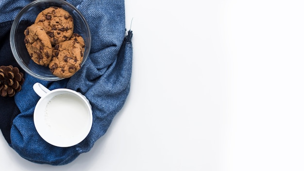 Taza de leche con plato de galletas en tela azul