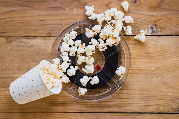 Taza de palomitas encima de la cinta de cine