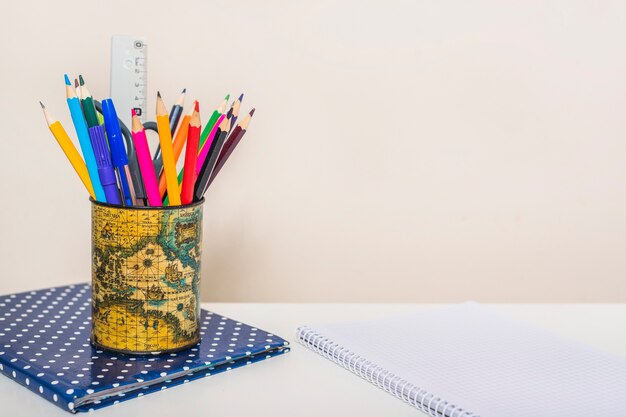 Taza con papelería en cuadernos