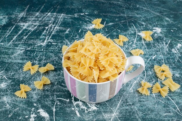 Taza de pasta farfalle en espacio azul.