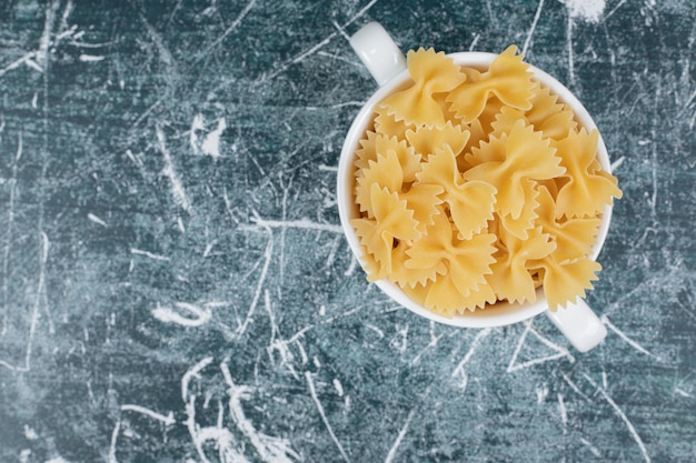 Taza de pasta farfalle sobre fondo azul. Foto de alta calidad