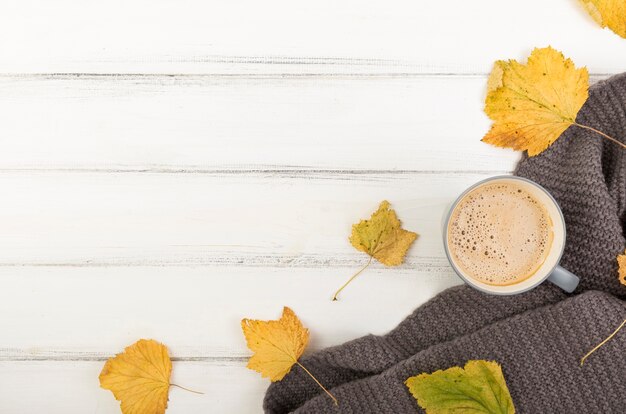 Taza plana de café y hojas de otoño con espacio de copia