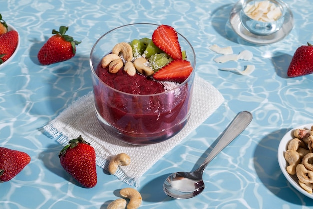 Taza de postre de açai de alto ángulo con fresas.