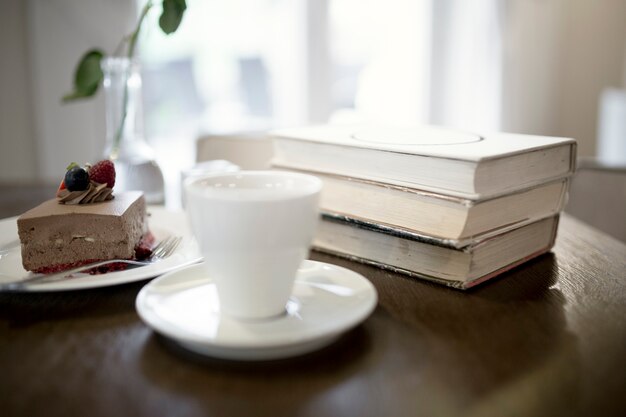 Taza y postre cerca de libros