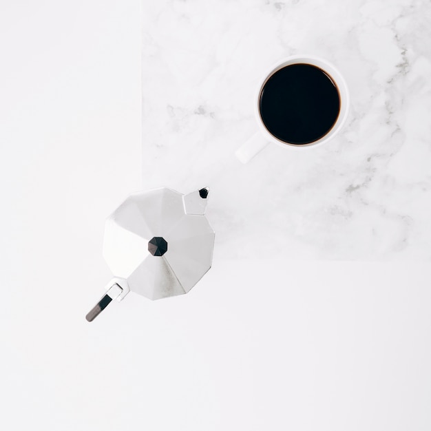Taza y pote de café en el fondo texturizado blanco