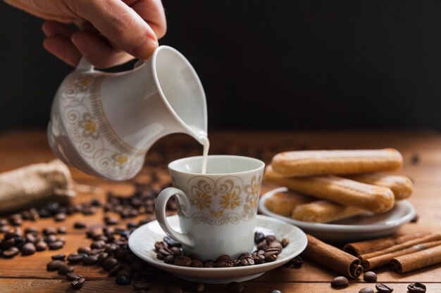 Taza de relleno de mano de cultivo con leche