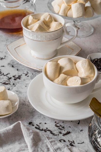 Foto gratuita taza de té de alto ángulo con merienda