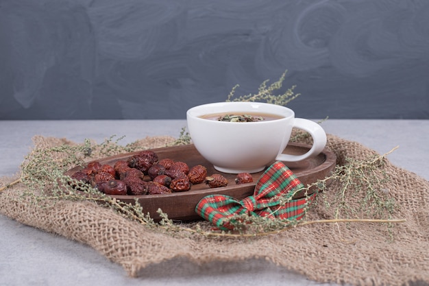 Taza de té y arándanos secos sobre arpillera. Foto de alta calidad