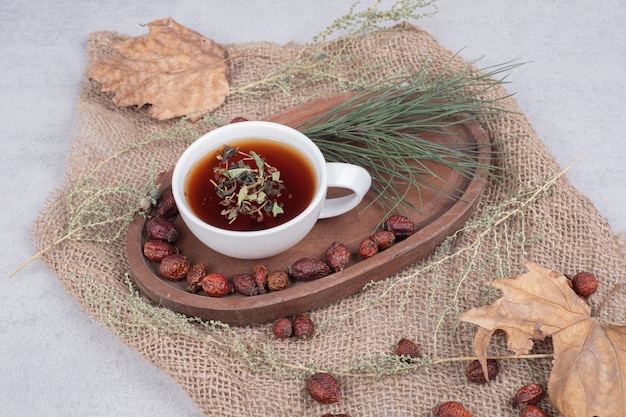 Taza de té y arándanos secos sobre arpillera. Foto de alta calidad