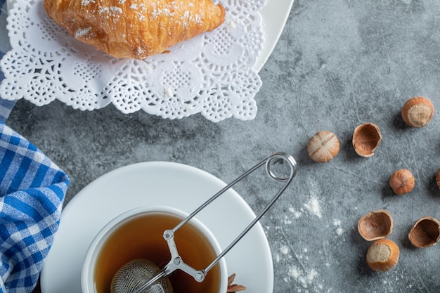 Taza de té aromática con deliciosos croissants.