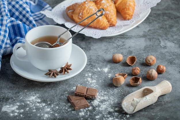 Taza de té aromática con deliciosos croissants.