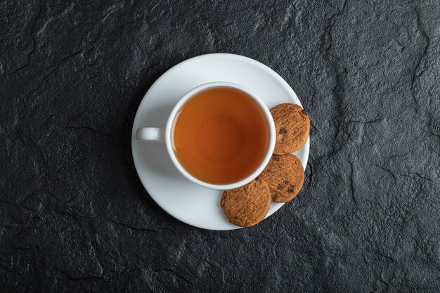 Una taza de té aromático con deliciosas galletas.