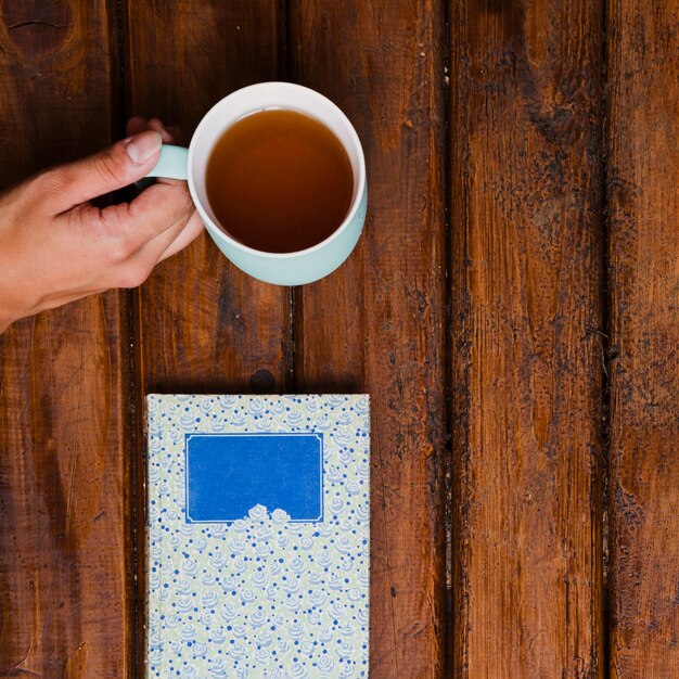 Taza de té aromático y libro sobre madera vieja