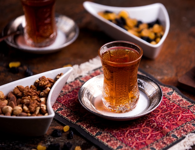 Taza de té aromático y tazón con nueces