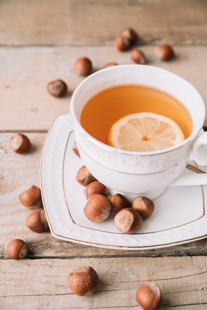 Foto gratuita taza de té y avellanas alta vista