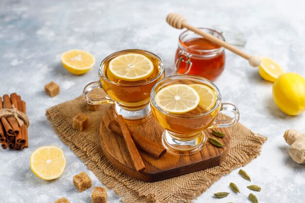 Una taza de té, azúcar morena, miel y limón sobre hormigón. Vista superior, espacio de copia